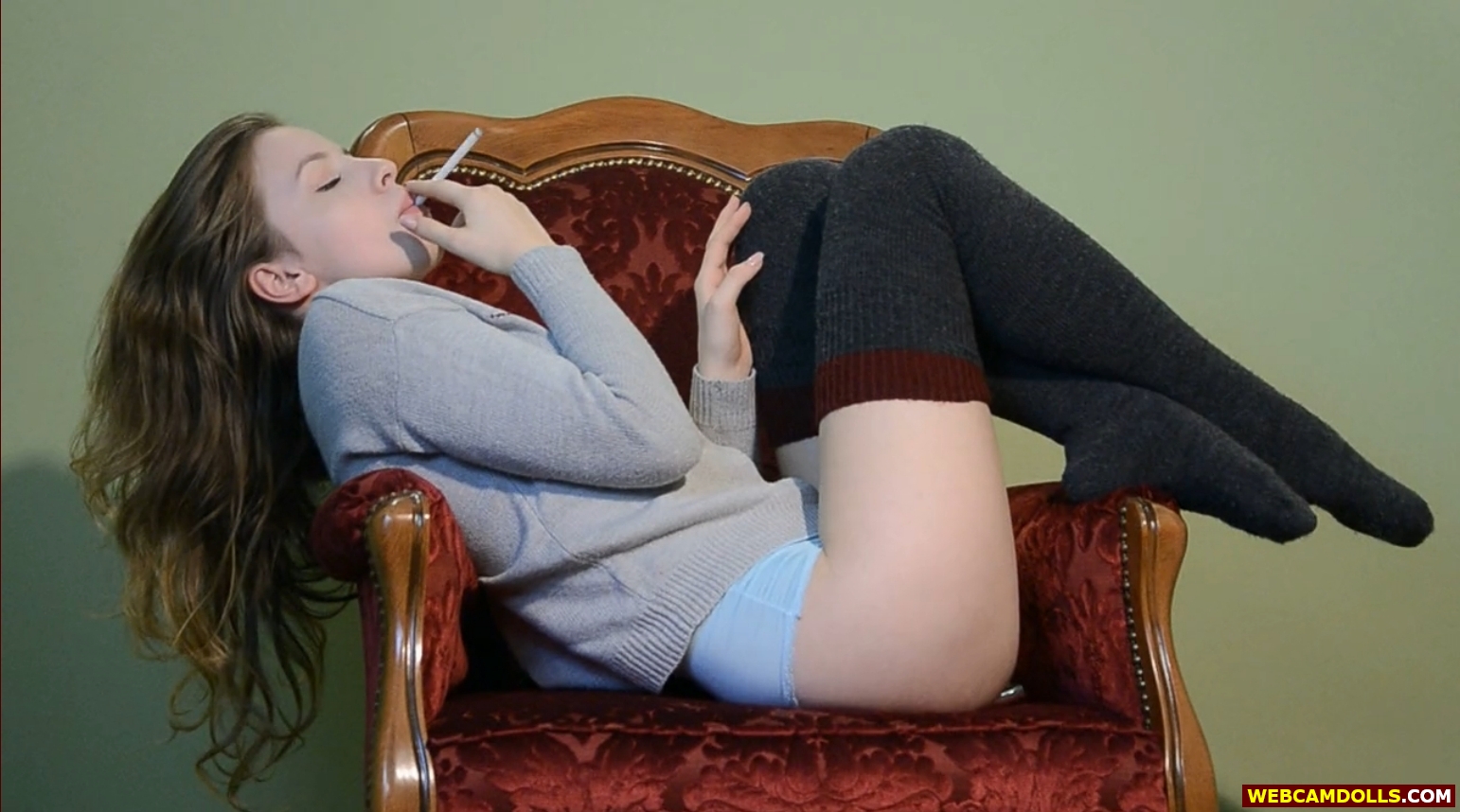 Blonde Teen Girl smoking in Black Woollen Stockings and Grey Sweater on Webcamdolls