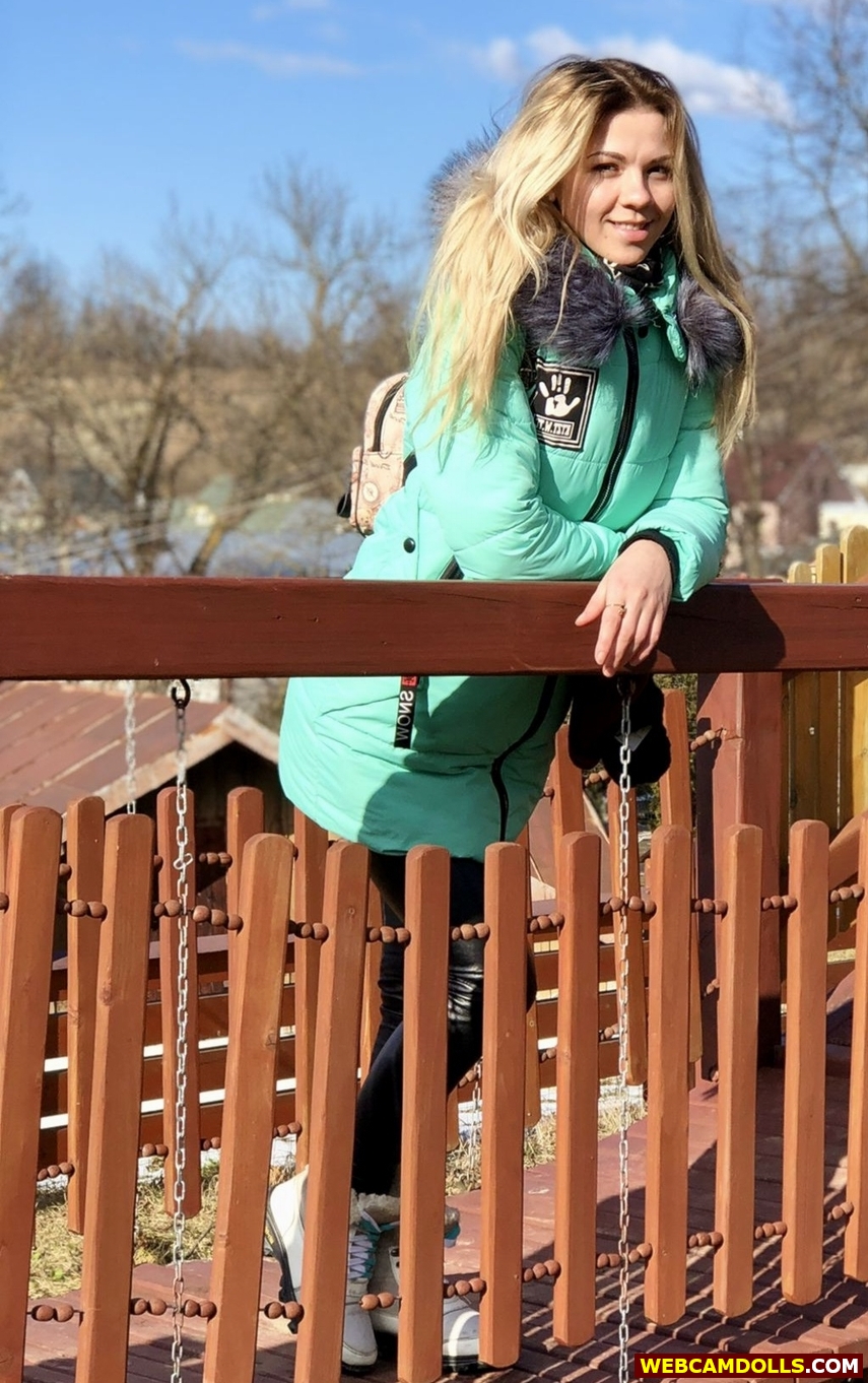 Blonde Girl in Black Ski Suit and Green Anorak on Webcamdolls